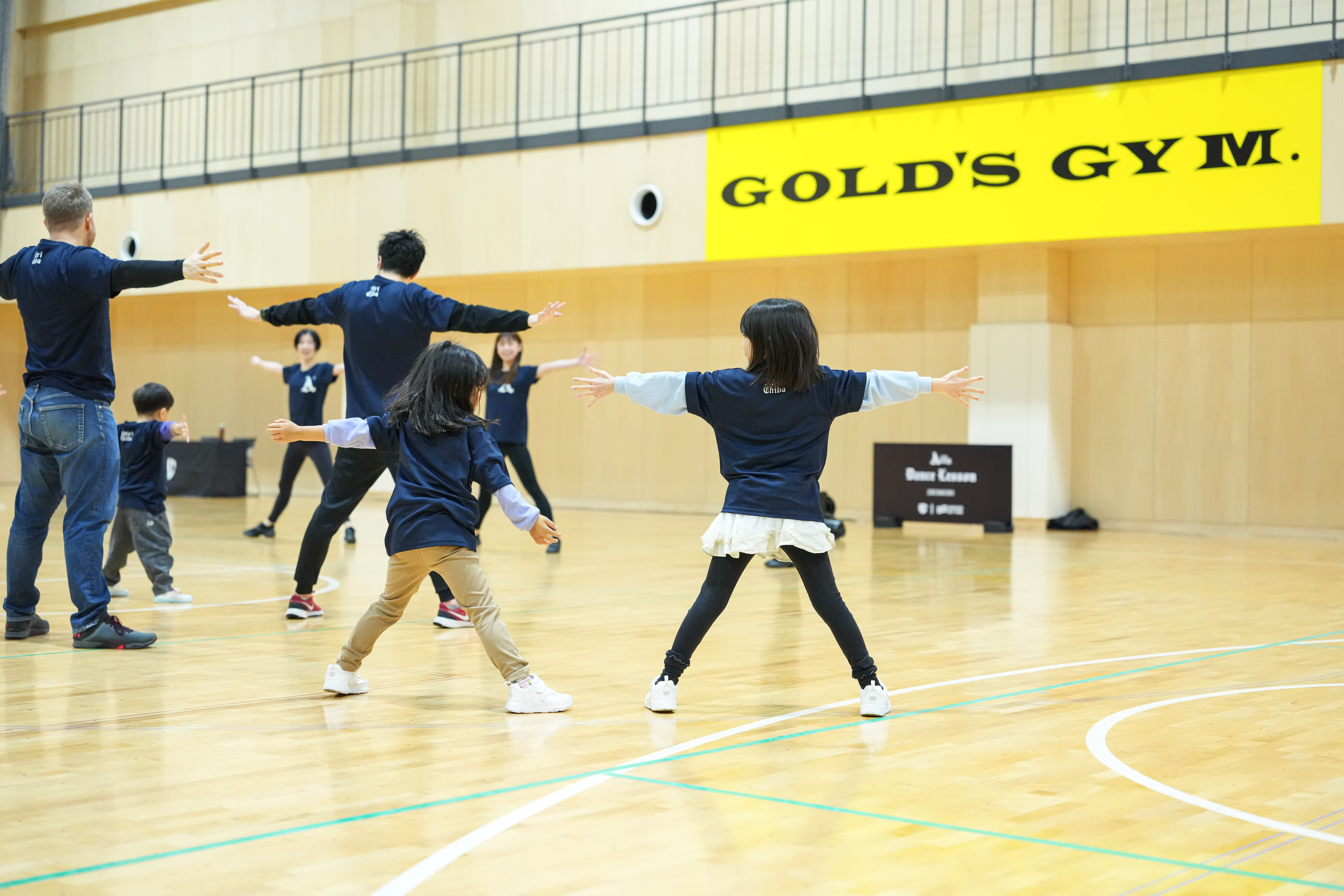 広いアリーナで身体を動かす子どもたち